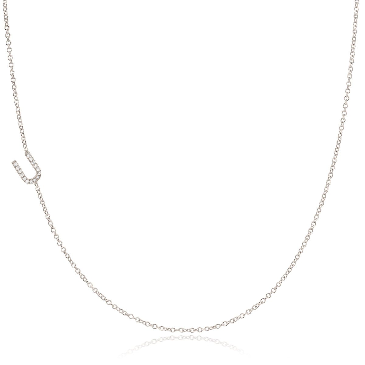 A white gold necklace with a letter U pave charm on a white background.