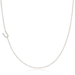 A white gold necklace with a letter U pave charm on a white background.