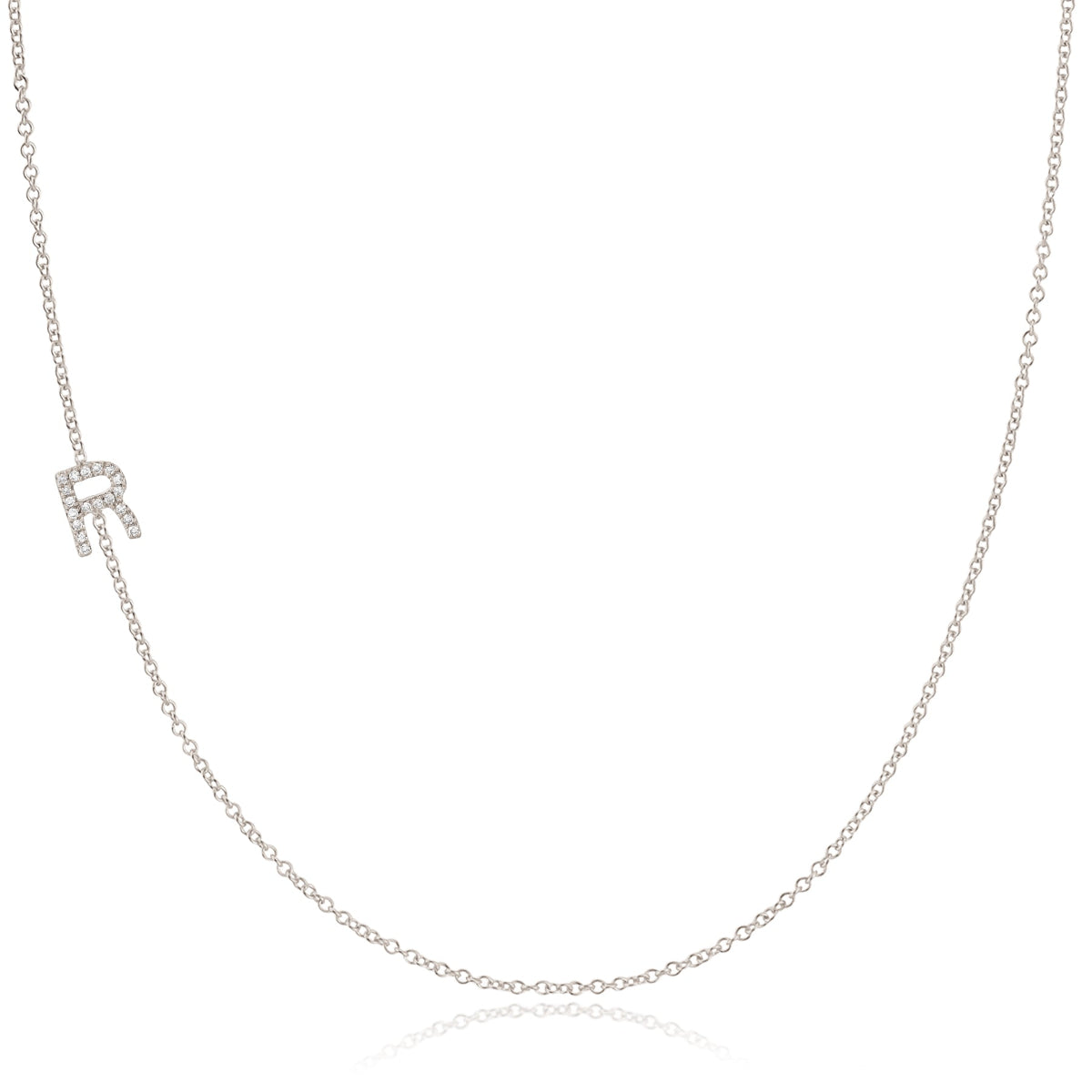 A white gold necklace with a letter R pave charm on a white background.