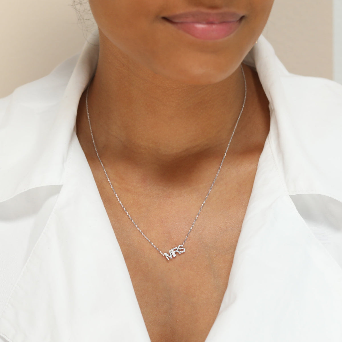 A Pavé MRS Necklace in white gold on a cable chain on a white background. 