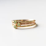 Three yellow gold Birthstone Rings in Peridot - August on a white background. 