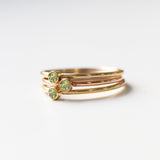 Three yellow gold Birthstone Rings in Peridot - August on a white background. 