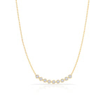 A Diamond Arc Layering Necklace in yellow gold on a white background. 
