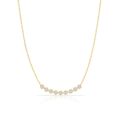 A Diamond Arc Layering Necklace in yellow gold on a white background. 