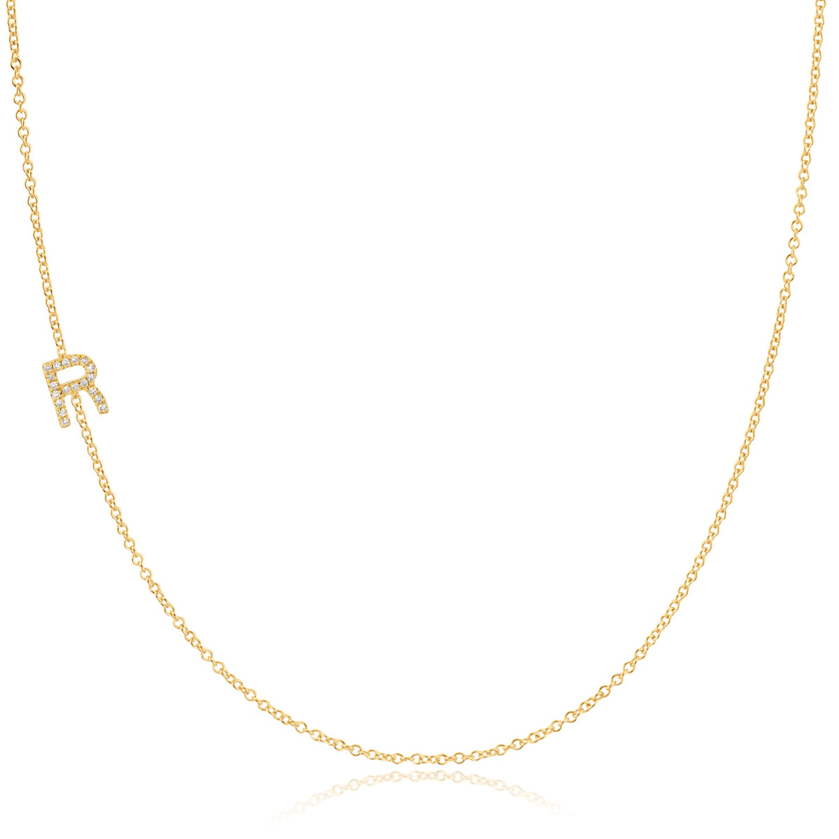 A yellow gold necklace with a pave letter R charm on a white background. 