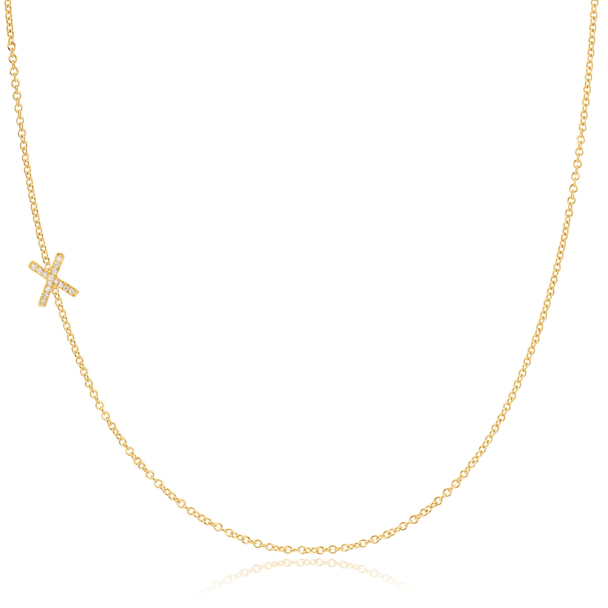 A yellow gold necklace with a pave letter X charm on a white background. 