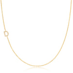 A yellow gold necklace with a pave letter D charm on a white background. 