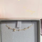 A yellow gold Custom Gold Bracelet – 5 Letters – with the letters M and A and three diamond birthstones, in a Maya Brenner jewellery box.