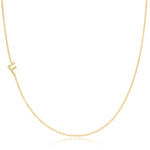 A yellow gold necklace with a pave letter F charm on a white background. 
