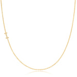 A yellow gold necklace with a pave letter I charm on a white background. 