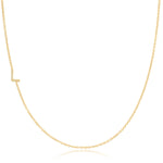 A yellow gold necklace with a pave letter L charm on a white background. 