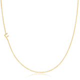 A yellow gold necklace with a F letter charm on a white background. 