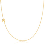 A yellow gold necklace with an N letter charm on a white background. 