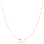 An OUI Necklace in yellow gold on a cable chain on a white background. 