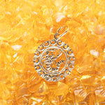 The Zodiac Necklace - Scorpio pendant laid on top of small yellow stones. 