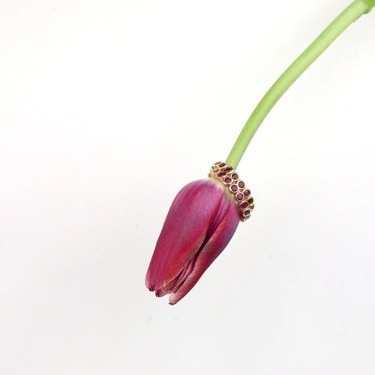 Two The Tulip Bouquet Rings on a red tulip against a light grey background. 