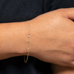 A wrist wearing a yellow gold Custom Gold Bracelet – 4 Letters  with the letters V, O, T and E, against a black background. 