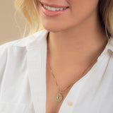 Close-up of a blonde woman wearing a Zodiac Necklace - Pisces with a white shirt against a neutral background. 