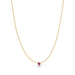 A Single Birthstone Layering Necklace - Yellow Gold in Ruby - July on a white background.