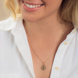 Close-up of a blonde woman wearing a Zodiac Necklace - Virgo with a white shirt against a neutral background. 