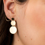 Close-up of an ear wearing a Cascading Solid Eclipse Earring and Open Eclipse Earring - Large. 